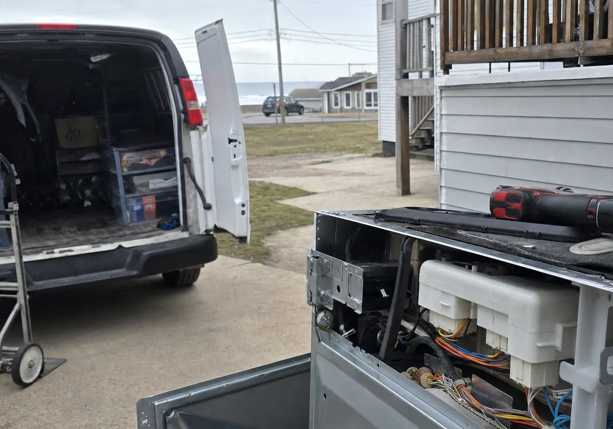 Centre crop of the open van doors, the parts bins filling the frame under overcast light.